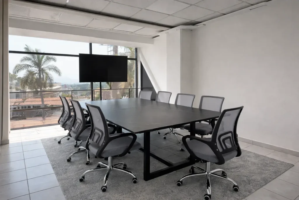 sala de juntas ejecutiva en Proyecto 9 Business Center con mesa corporativa y pantalla para presentaciones